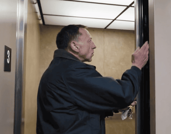 A Stanley Elevator technician inspects the sliding door of an elevator during an elevator safety inspection.
